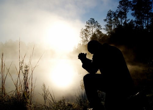 Man sitting in the dark praying
