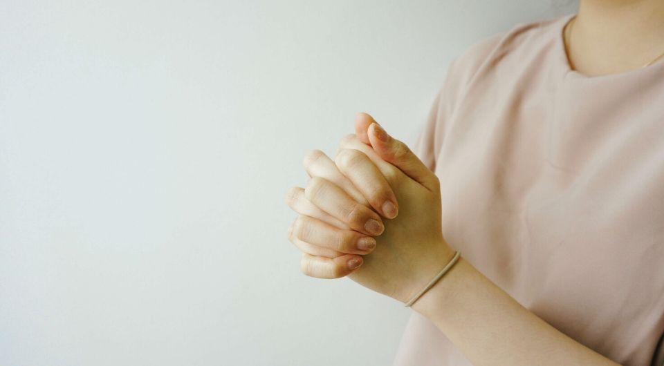 Woman with hands clasp together praying