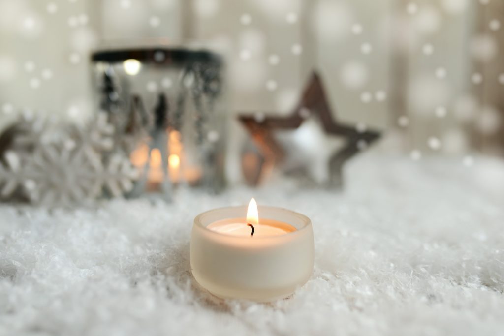 lit candle on snow